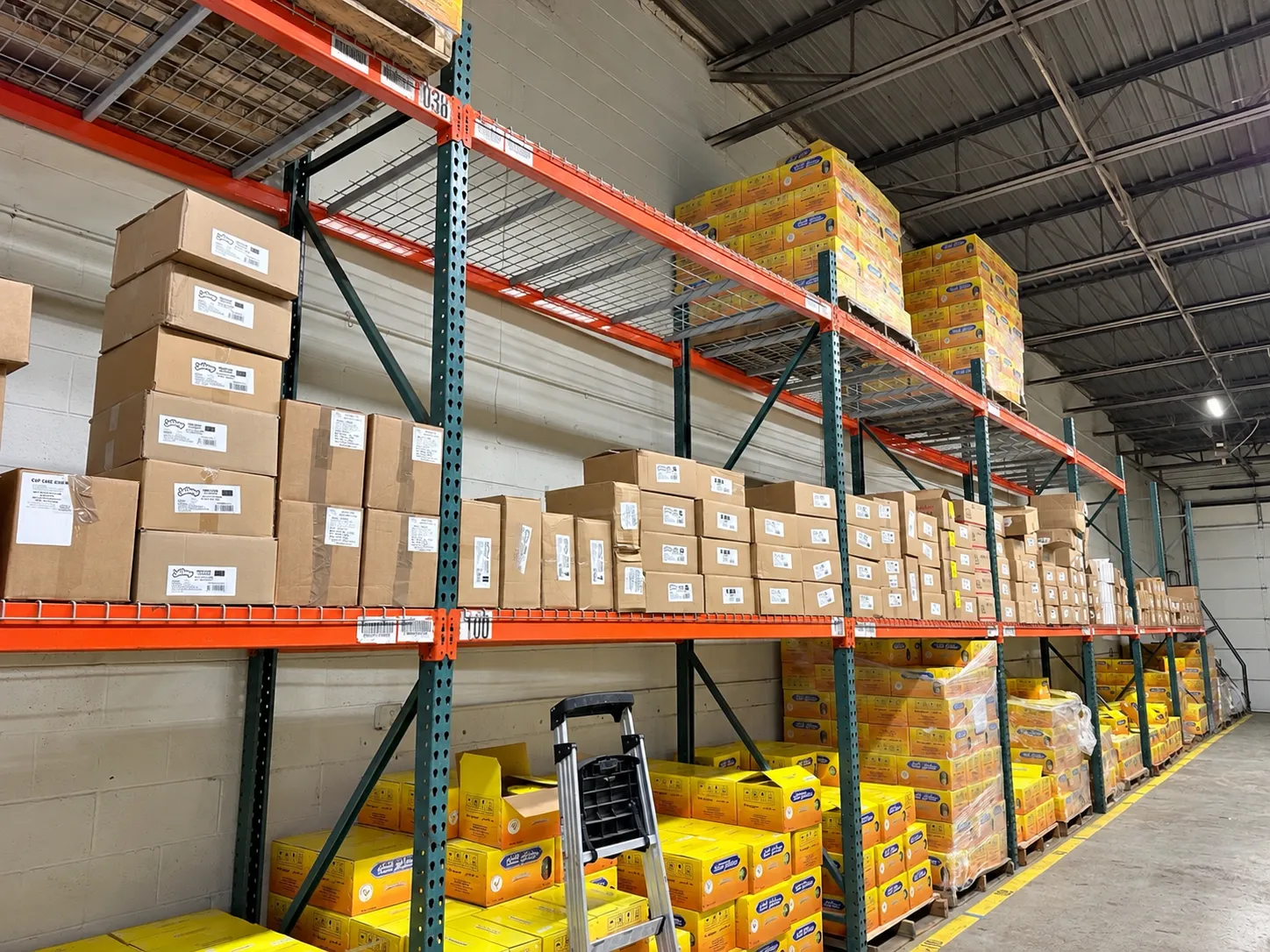 Warehouse aisle lined with racked, labeled cartons