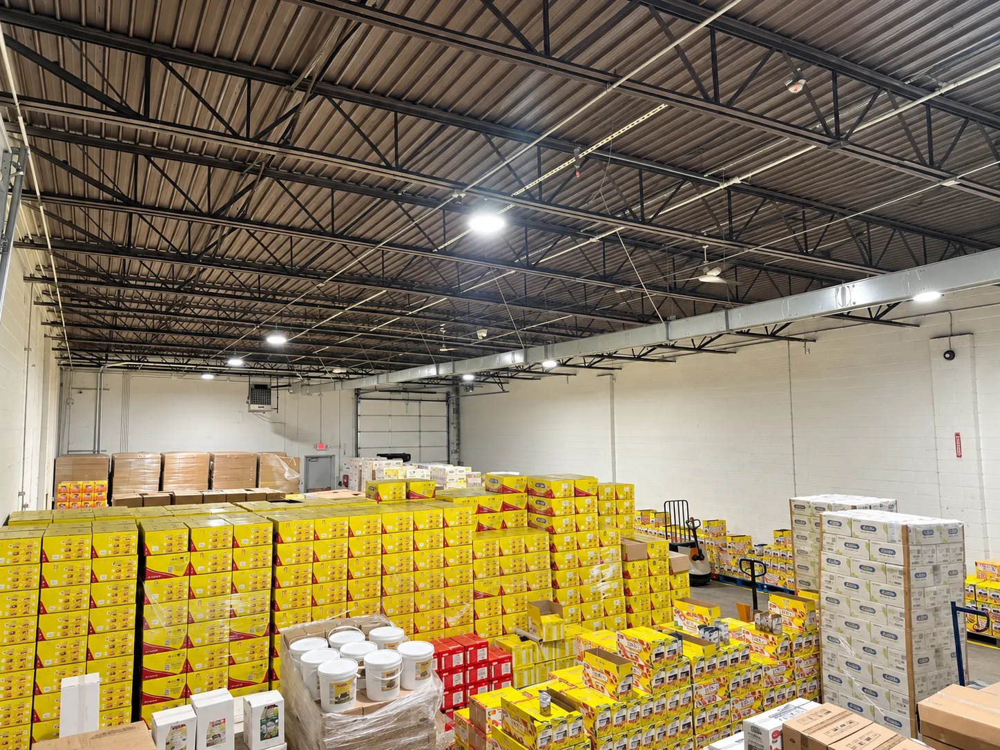 High-ceiling warehouse floor with palletized inventory stacked and ready to pick